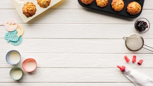 Top view of delicious muffins and baking tools on wooden table with copy space — Stock Photo