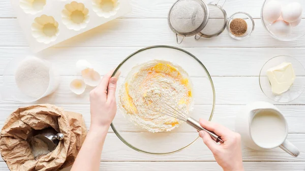 Vista ritagliato di donna mescolando pasta cupcake in ciotola sul tavolo — Foto stock