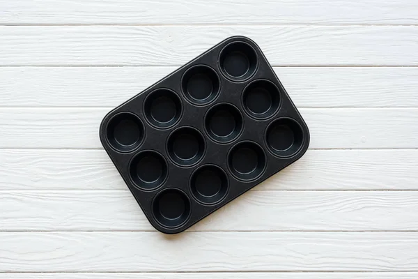 Top view of metal muffin tray on white wooden table — Stock Photo