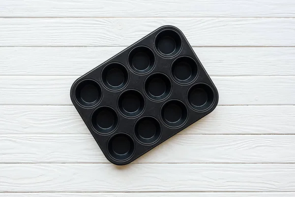 Vue du dessus du plateau à muffins en métal sur une table en bois blanc — Photo de stock