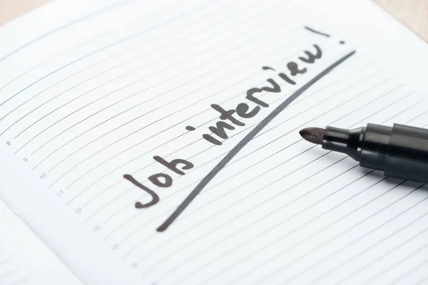 Close up of job interview lettering on white paper near black marker — Stock Photo