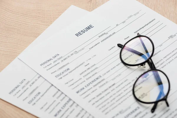 Nahaufnahme von Drucklebenslauf-Vorlagen und Stift auf Holztisch — Stockfoto