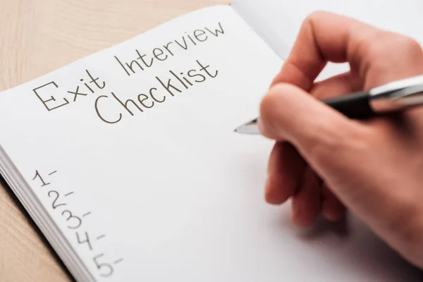 Cropped view of recruiter writing in notebook with exit interview checklist lettering — Stock Photo