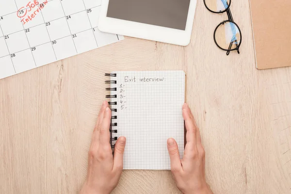 Cropped view of recruiter holding notebook with exit interview lettering — Stock Photo