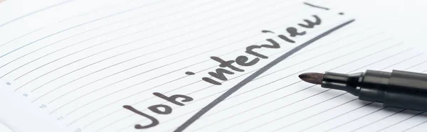 Panoramic shot of job interview lettering on white paper near black marker — Stock Photo