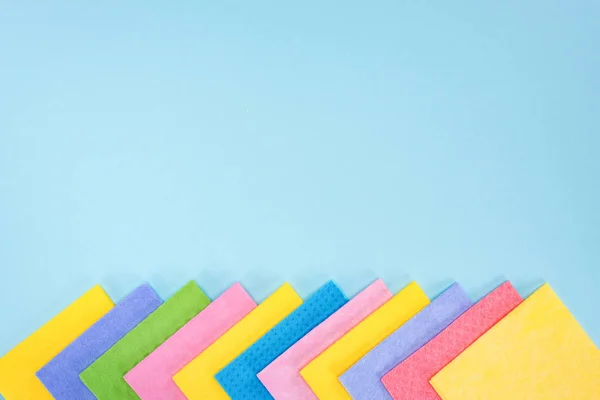 Multicolored rags on blue background with copy space — Stock Photo