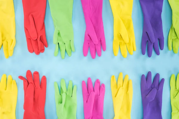 Flat lay com luvas de borracha multicoloridas no fundo azul — Fotografia de Stock