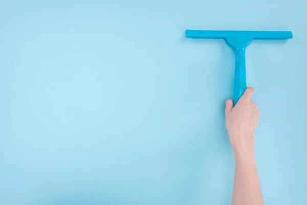 Vista recortada de la mujer que sostiene la escobilla sobre fondo azul - foto de stock