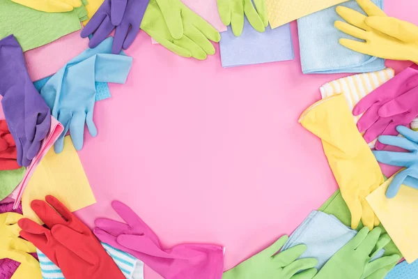 Top view of messy scattered multicolored rags and rubber gloves on pink background with copy space — Stock Photo