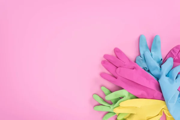 Vista superior de luvas de borracha multicoloridas no fundo rosa com espaço de cópia — Fotografia de Stock