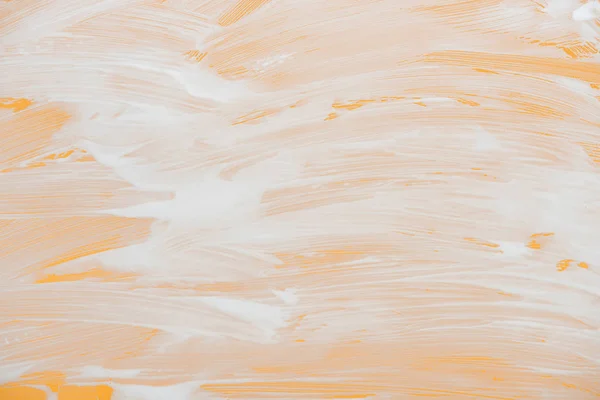 Vidrio cubierto con espuma blanca sobre fondo naranja - foto de stock