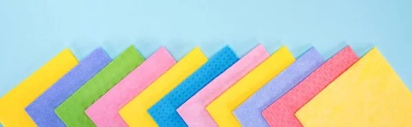 Panoramic shot of bright multicolored rags on blue background — Stock Photo