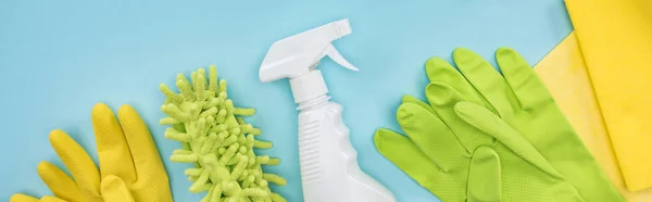 Panoramic shot of cleaning supplies on blue background — Stock Photo