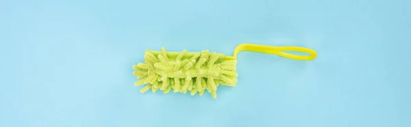 Panoramic shot of green bright sponge for cleaning on blue background — Stock Photo