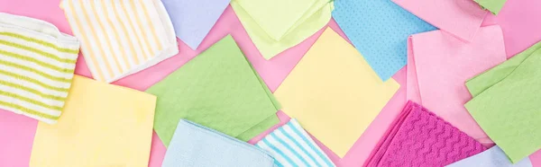 Panoramic shot of messy scattered colorful rags on pink background — Stock Photo