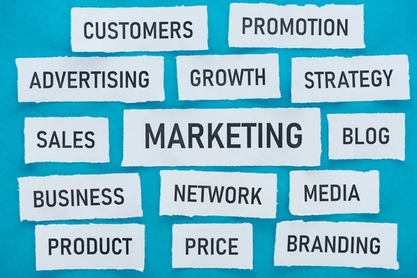 Top view of components related to marketing on pieces of paper on blue — Stock Photo