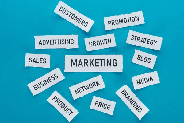 Top view of components of marketing on pieces of paper on blue — Stock Photo