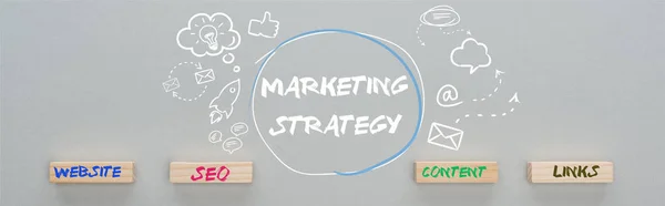 Panoramica della strategia di marketing iscrizione vicino a icone multimediali illustrazione e blocchi di legno con sito web, seo, contenuti, link parole su sfondo grigio, concetto di business — Foto stock