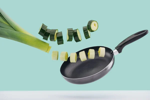 Chopped organic vegetables in frying pan isolated on turquoise — Stock Photo