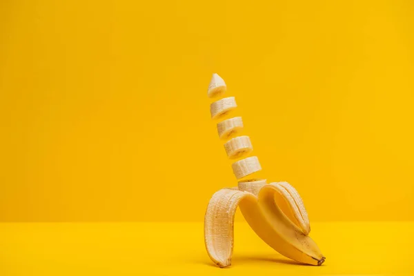 Half sliced fresh sweet tasty banana isolated on yellow — Stock Photo