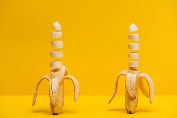 Two freshly sliced delicious bananas isolated on yellow — Stock Photo