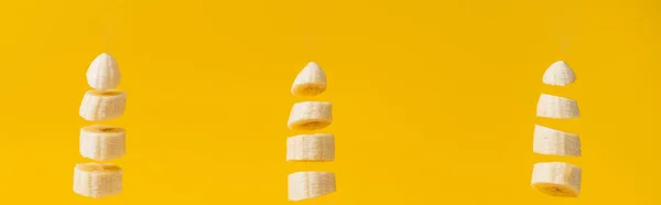 Prise de vue panoramique de bananes sucrées nutritives, coupées en tranches, isolées sur du jaune — Photo de stock