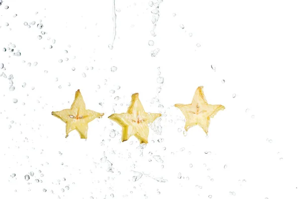 Rodajas de fruta fresca y exótica estrella y gotas de agua aisladas en blanco - foto de stock