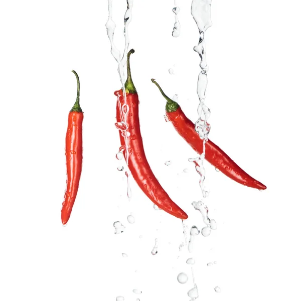 Bright spicy red chili peppers with clear water streams isolated on white — Stock Photo