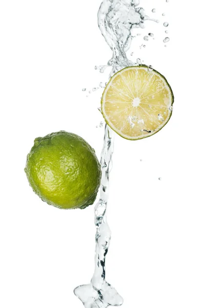 Limes freschi verdi con flusso di acqua limpida e gocce isolate su bianco — Foto stock