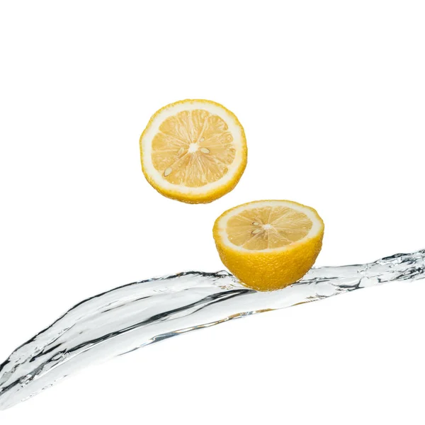 Yellow fresh lemons with clear water stream isolated on white — Stock Photo