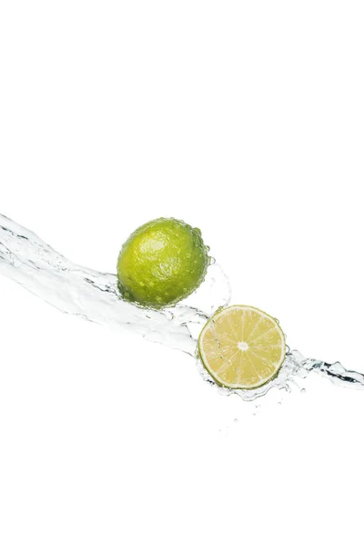 Green fresh limes with clear water stream isolated on white with copy space — Stock Photo