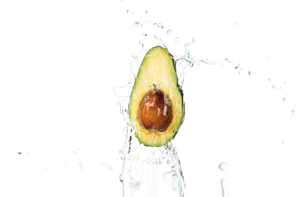 Aguacate nutritivo maduro medio con semilla y salpicadura de agua transparente con gotas aisladas en blanco - foto de stock