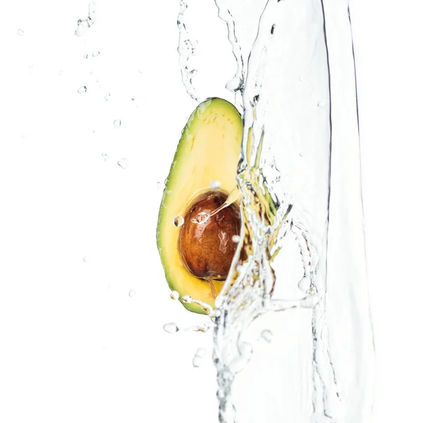 Ripe nutritious avocado half with seed and water splash with drops isolated on white — Stock Photo