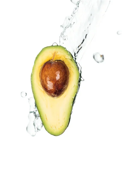 Moitié d'avocat nutritif avec des graines et éclaboussure d'eau transparente avec des gouttes isolées sur blanc — Photo de stock