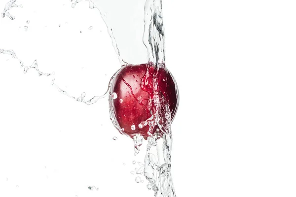 Whole ripe red apple and clear water stream with drops isolated on white — Stock Photo