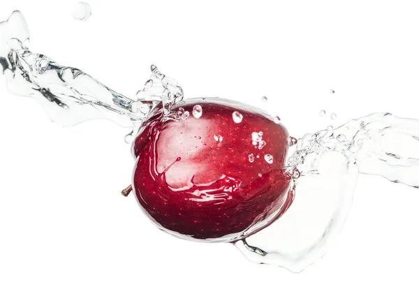 Maçã vermelha madura inteira e respingo de água clara com gotas isoladas em branco — Fotografia de Stock