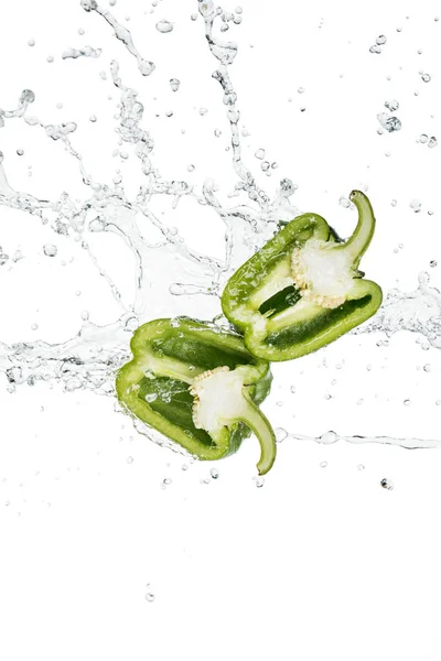 Poivron vert frais moitiés et éclaboussures d'eau avec des gouttes isolées sur blanc — Photo de stock