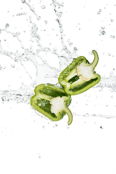 Pimentão verde fresco metades e respingo de água com gotas isoladas em branco — Fotografia de Stock