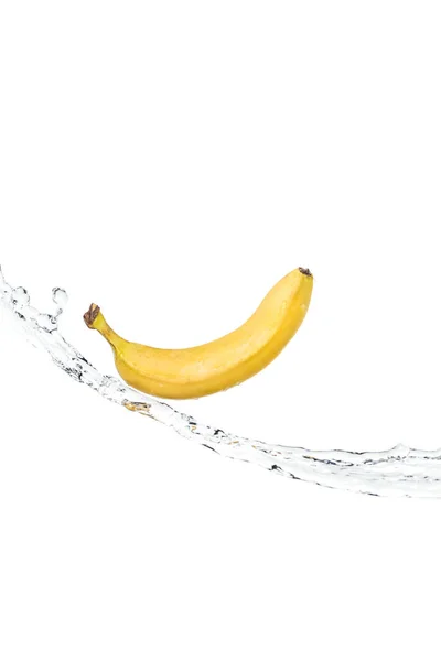 Цілий стиглий жовтий банан на водному потоці ізольований на білому — стокове фото