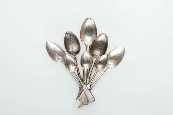 Vista dall'alto di lucidi vecchi cucchiai vuoti d'argento su sfondo bianco — Foto stock