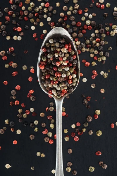 Top view of mix pepper spice in silver spoon on black background — Stock Photo