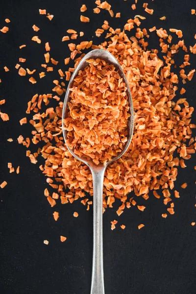 Top view of orange candied fruit in silver spoon on black background — Stock Photo