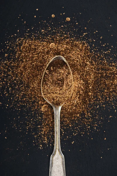 Top view of cumin in silver spoon on black background — Stock Photo