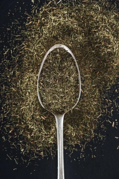 Vista superior de erva-doce em colher de prata no fundo preto — Fotografia de Stock