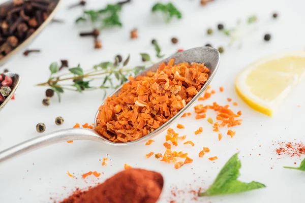 Vista de cerca de fruta confitada naranja en cuchara de plata sobre fondo blanco - foto de stock