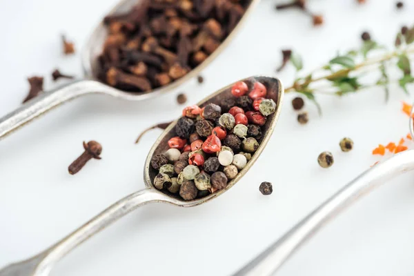 Close up view of pepper mix in silver spoon on white background — Stock Photo