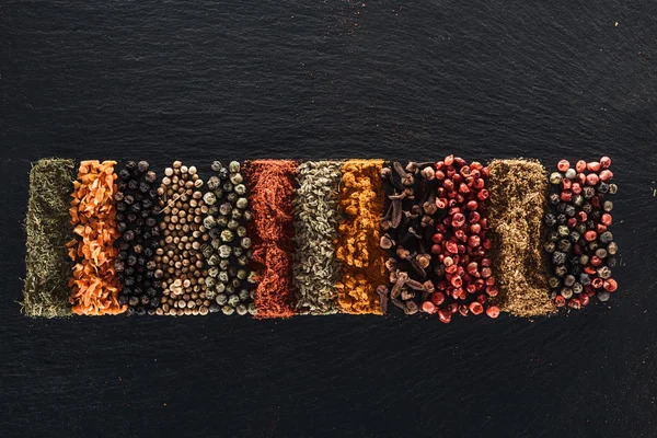 Top view of traditional bright indian spices on textured black background — Stock Photo