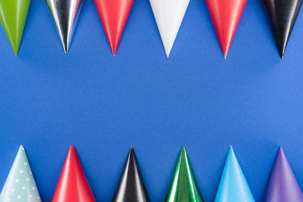 Цветные шляпы на голубом фоне с копировальным пространством — стоковое фото