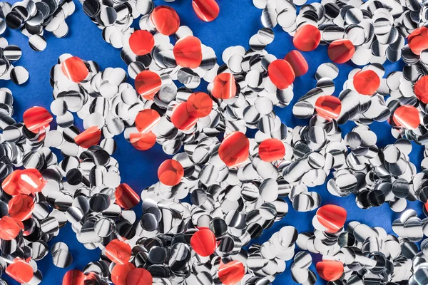 Top view colorful pieces of confetti on blue background — Stock Photo