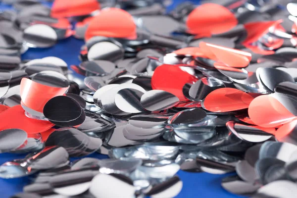 Selective focus of silver and red confetti on blue background — Stock Photo